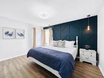 a bedroom with a large bed with a blue accent wall at NEW Luxury 7BR Villa 4 Mi to Disney Pool & Spa in Kissimmee