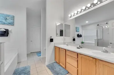 a bathroom with two sinks and a large mirror at 5BR 4BA Near Disney, Pool, Sauna, Pets Allowed in Kissimmee