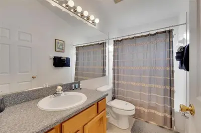 a bathroom with a sink and a toilet at 5BR 4BA Near Disney, Pool, Sauna, Pets Allowed in Kissimmee