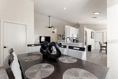 a kitchen and living room with a table and chairs at Magical Hideaway at Kissimmee by Shine Villas villa in Kissimmee