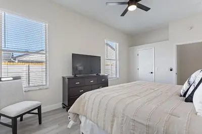 a bedroom with a bed and a tv and a chair at Magical Hideaway at Kissimmee by Shine Villas villa in Kissimmee