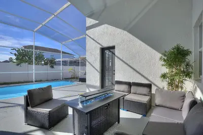 a patio with chairs and a table and a pool at Magical Hideaway at Kissimmee by Shine Villas villa in Kissimmee