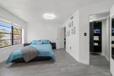 a white bedroom with a bed and a window at Condo with Pool, Gym, Golf, Jacuzzi and Game Areas in Orlando