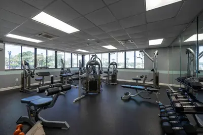 a gym with several treadmills and machines in it at Condo with Pool, Gym, Golf, Jacuzzi and Game Areas in Orlando