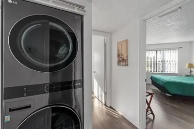 a washing machine in a room with a bedroom at Cozy Apt with Pool, Hot Tub, Golf, Near Downtown in Orlando