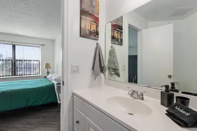 a bathroom with a sink and a mirror and a bed at Cozy Apt with Pool, Hot Tub, Golf, Near Downtown in Orlando