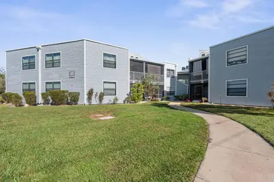 a large building with a grass yard in front of it at Cozy Apt with Pool, Hot Tub, Golf, Near Downtown in Orlando