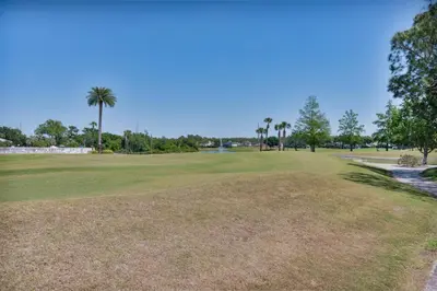 a view of a golf course with palm trees at Cozy Golf Condo with 3 Pools, Gym and Just 15 Minutes to Airport in Orlando