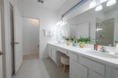 a white bathroom with two sinks and a mirror at 2026 NEW Home 8 Bedrooms At Bella Vida in Kissimmee