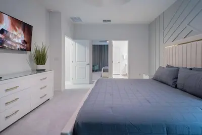 a bedroom with a bed and a dresser and a tv at 2026 NEW Home 8 Bedrooms At Bella Vida in Kissimmee