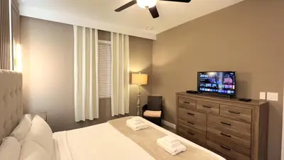 a bedroom with a bed and a television on a dresser at 4573TB-New Listing- 10bed/5 bath-Private Pool in Kissimmee