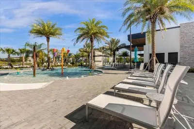 a row of white lounge chairs in front of a pool at 6277SK-New Brand-12bed/11.5bath-Private Pool&SPA in Orlando