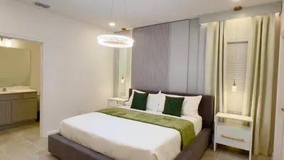a bedroom with a bed and a bathroom with a sink at 6277SK-New Brand-12bed/11.5bath-Private Pool&SPA in Orlando