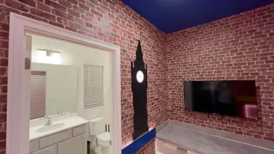 a bathroom with a brick wall with a tv on the wall at 6277SK-New Brand-12bed/11.5bath-Private Pool&SPA in Orlando