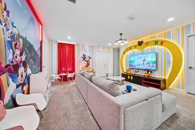 a living room with a couch and a tv at Brand NEW Home 09 BedroomsPoolGame Room in Kissimmee