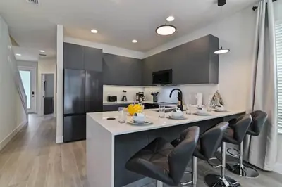 a kitchen with a large white island with black cabinets at New townhouse in Clermont -Orlando area in Orlando