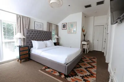 a bedroom with a large white bed and a window at Norment Parry by The Wellborn in Orlando