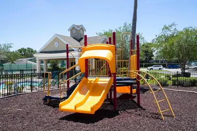 a playground with a yellow slide in a park at True Fantasies 101 in Kissimmee