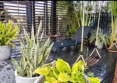 a patio with potted plants and a swing at Elegant Home near Disney - pool - free parking in Kissimmee