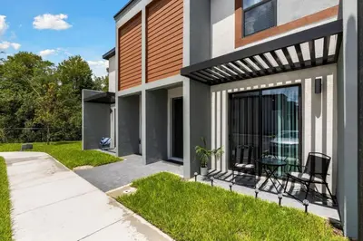 a home with a patio with a table and chairs at Elegant Home near Disney - pool - free parking in Kissimmee