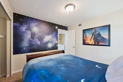 a bedroom with a large painting on the wall at Near Disney! Pool and Hot Tub with Free Parking in Kissimmee