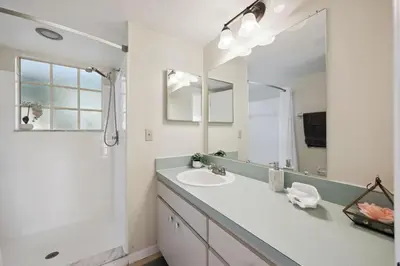 a bathroom with a sink and a large mirror at Near Disney! Pool and Hot Tub with Free Parking in Kissimmee