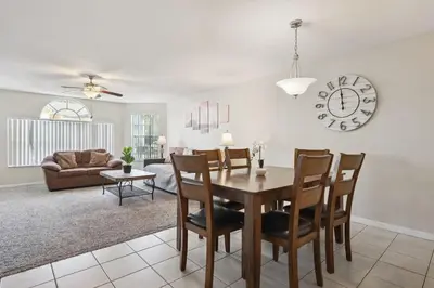 a dining room and living room with a table and chairs at Near Disney! Pool and Hot Tub with Free Parking in Kissimmee