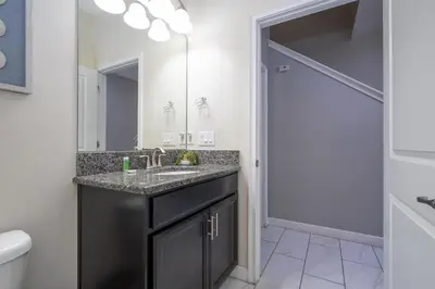 a bathroom with a sink and a mirror at Townhome 4Q c/ Piscina Privativa – Storey Lake in Kissimmee