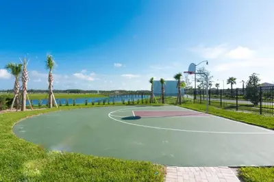 a basketball court in a park next to the water at Townhome 4Q c/ Piscina Privativa – Storey Lake in Kissimmee