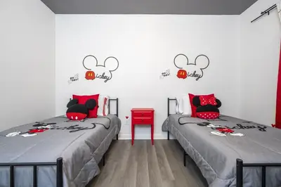 two twin beds in a room with a wall with mickey ears at Apto 3Q em Kissimmee – Conforto e Localização in Kissimmee