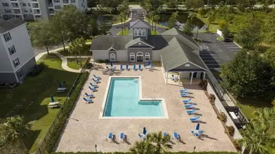 an aerial view of a pool with lounge chairs and a house at Apto 3Q em Kissimmee – Conforto e Localização in Kissimmee