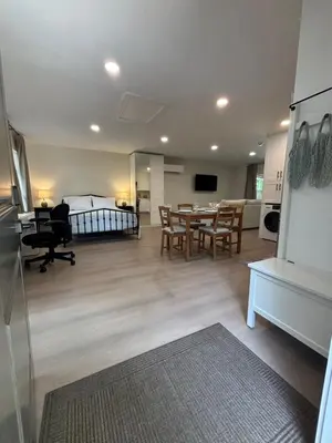 a living room with a bed and a table and chairs at Parks2Coast Trail Casita in Sanford
