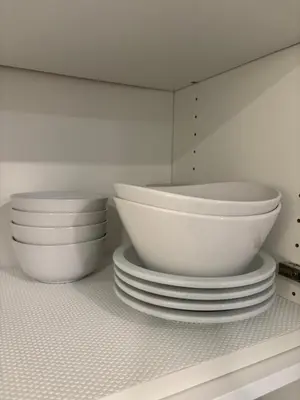 a white kitchen with bowls and plates on a shelf at Parks2Coast Trail Casita in Sanford