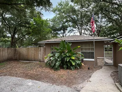 a house with an american flag in front of it at Parks2Coast Trail Casita in Sanford