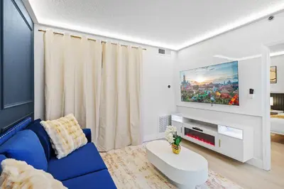 a living room with a blue couch and a tv at Well-Located 1BR Kitchen Near Theme Parks in Orlando