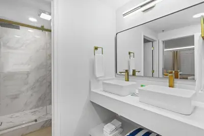 a white bathroom with two sinks and a mirror at Well-Located 1BR Kitchen Near Theme Parks in Orlando