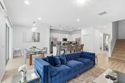 a living room and dining room with a blue couch at Large Orlando Home 8BR Great Location in Kissimmee