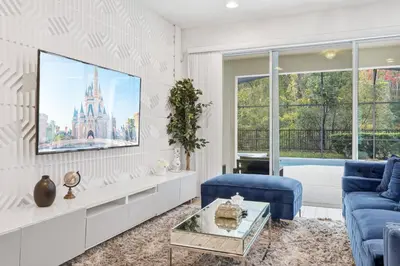 a living room with a blue couch and a tv at Large Orlando Home 8BR Great Location in Kissimmee