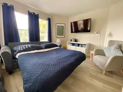 a bedroom with a bed and a couch and a chair at Sea World Orlando Apts Parks Convention Centre in Orlando