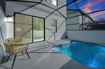 a house with a swimming pool and a chair at New 5BR Villa Near Disney I Resort Lazy River in Orlando