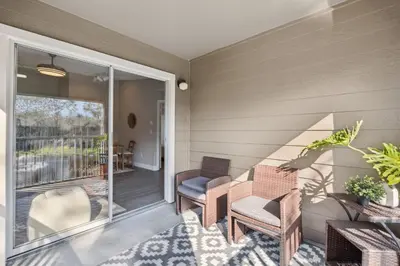 a screened porch with chairs and a table at Quiet Gated Condo Near Universal with Pool and View in Orlando