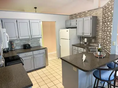 a kitchen with white cabinets and a white refrigerator at Magic getaway in Kissimmee
