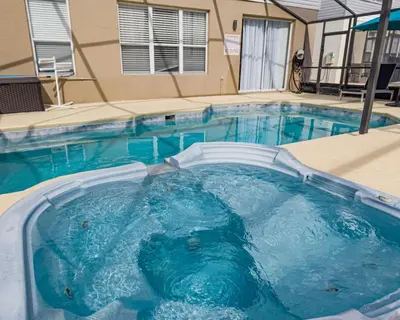 a large swimming pool with blue water at Magic Palms House 10 Min to Parks in Kissimmee