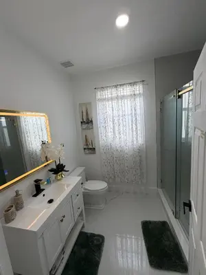 a bathroom with a toilet and a sink and a shower at Magic Palms House 10 Min to Parks in Kissimmee