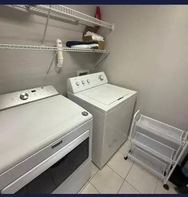 a small kitchen with a stove and a washer at TownHouse at Emerald Island Resort Near Disney in Kissimmee