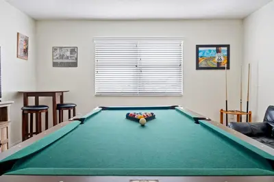 a living room with a pool table and chairs at Family Retreat at Lake Berkley Resort! in Kissimmee