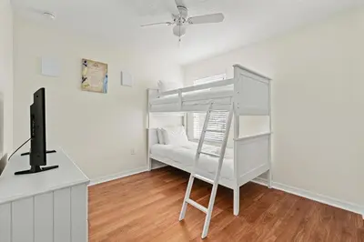 a room with a bunk bed and a desk with a television at Family Retreat at Lake Berkley Resort! in Kissimmee