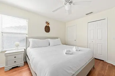 a white bedroom with a bed and a ceiling fan at Family Retreat at Lake Berkley Resort! in Kissimmee