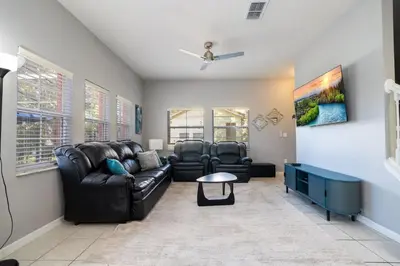 a living room with a leather couch and chairs at Condomínio Encantada c/ Piscina & Vista ao Lago in Kissimmee