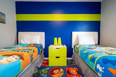 a bedroom with two beds and a blue and yellow wall at Condomínio Encantada c/ Piscina & Vista ao Lago in Kissimmee
